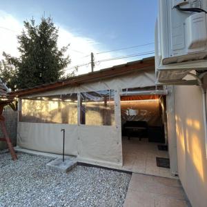 a building with a white wall and a garage at Flóra vendégház Tiszafüred in Tiszafüred