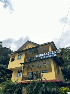 un edificio amarillo con un cartel encima en Highlanders Garden Guesthouse at Arundina Cameron Highlands en Cameron Highlands