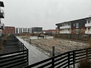 una obra de construcción con una valla y edificios en Apartament Moderato, en Starogard Gdański