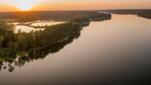 eine Luftansicht eines Flusses bei Sonnenuntergang in der Unterkunft Natural Hotel w Rezerwacie przy plaży na wyspie in Ostróda