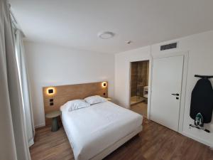 1 dormitorio con cama blanca y cabecero de madera en Appart'hôtel Marianne en Montpellier