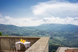 - Balcón con mesa y sillas y vistas a las montañas en Hotel Cesare en San Marino