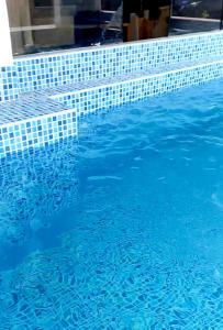 una piscina azul con azulejos azules. en Departamento de verano - CAMANA en Camaná