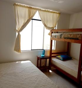 1 dormitorio con 2 literas y ventana en Departamento de verano - CAMANA en Camaná