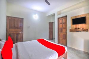 a bedroom with a red and white bed and a tv at Roseal Water Front in Baga