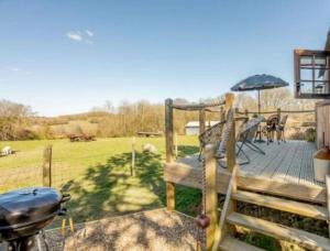 une terrasse avec un grill, un banc et un parasol dans l'établissement Pooks Rest, à Hurst Green