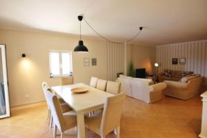 een eetkamer en een woonkamer met een tafel en stoelen bij Da Praia Apartment - Pool & Tenis in Vilamoura