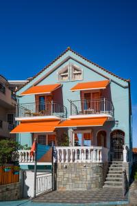 Una gran casa con balcones naranjas y escaleras en Belleza Villa, en Lixouri