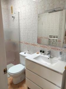 a white bathroom with a toilet and a sink at Casa Azabara in San José