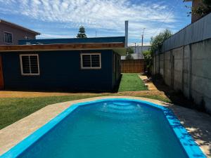 una piscina azul frente a una casa en Alojamiento rústico Belloto (3) en Quilpué