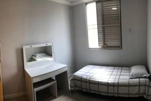 een slaapkamer met een bed, een wastafel en een spiegel bij Apartamento completo, com excelente localização in Americana