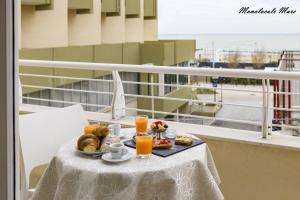 een dienblad met eten op een tafel op een balkon met sinaasappelsap bij Casa Stefania Rimini in Rimini