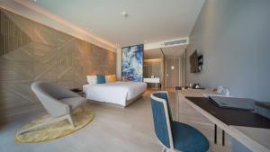 una camera con letto e scrivania con sedia di The Nature Phuket - SHA Extra Plus a Patong Beach