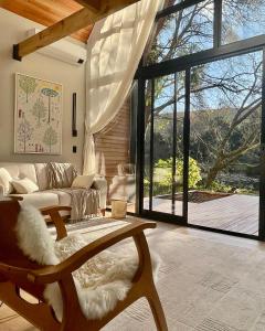 a living room with a couch and a large window at Cabanas Jardim de Tereza in São Joaquim