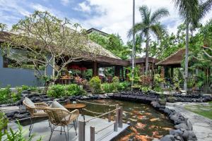 um jardim com um lago em frente a uma casa em Tonys Villas & Resort Seminyak - Bali em Seminyak