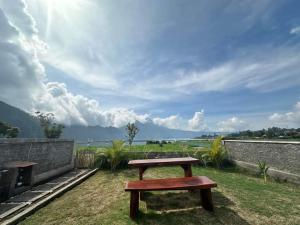 un banc en bois assis au-dessus d'un champ dans l'établissement Volcano Cabins, à Kubupenlokan