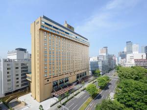 a tall building in the middle of a city at Nagoya Kanko Hotel in Nagoya