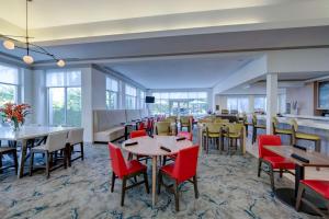 uma sala de jantar com mesas, cadeiras e janelas em Hilton Garden Inn Anaheim/Garden Grove em Anaheim