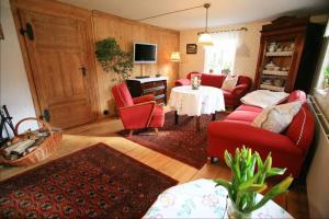 sala de estar con sillas rojas y mesa en Ferienhaus Spreewaldnostalgie en Burg