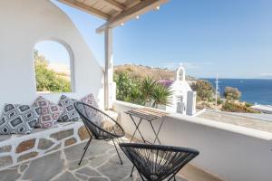 d'un balcon avec des chaises, un banc et l'océan. dans l'établissement Blue Moon Mykonos Homes, à Mykonos