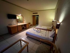 a bedroom with two beds and a desk and a mirror at Sharm Cliff Hotel in Sharm El Sheikh