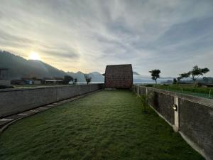 un bâtiment sur un mur avec une pelouse dans l'établissement Volcano Cabins, à Kubupenlokan