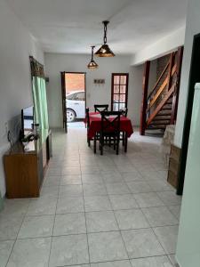 a dining room with a red table and chairs in a room at Cabaña en el Centro de Mina Clavero in Mina Clavero