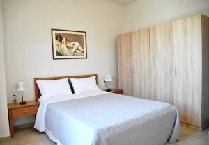 1 dormitorio con cama blanca y armario de madera en Christina's Seaside en Afissos