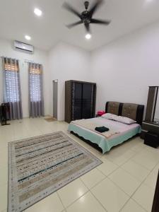 een slaapkamer met een bed en een plafondventilator bij Homestay Gua Musang in Gua Musang