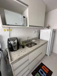 a small kitchen with a sink and a microwave at Loft 511 Super Aconchegante no Coração de Teresópolis in Teresópolis