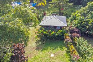 una pequeña casa en medio de un jardín en 3 Rivers Eco Lodge en Rosalie