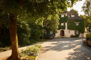 uma casa numa rua com uma árvore e uma entrada em Gästehaus Englischer Garten em Munique