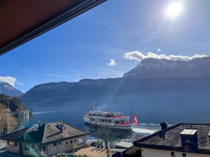 łódź na wodzie z górami w tle w obiekcie Seehotel Riviera at Lake Lucerne w mieście Gersau