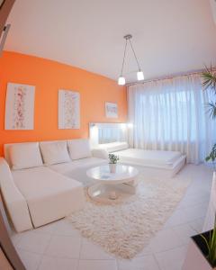 sala de estar con sofá blanco y pared de color naranja en Alex Botique, en Varna