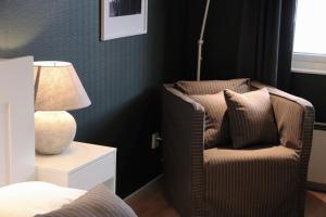 une chambre avec une chaise et une lampe sur une table de chevet dans l'établissement Hotell Miskarp, à Mjölby