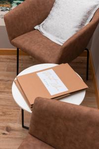 a book sitting on a table next to a chair at Hotel Sveta Ana in Donji Humac