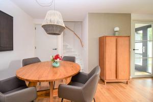 a dining room with a wooden table and chairs at Skylgerduin in Midsland