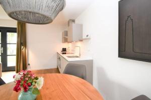 a kitchen with a table with a vase of flowers at Skylgerduin in Midsland