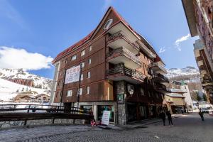 un bâtiment dans une rue avec des montagnes en arrière-plan dans l'établissement HelloChalet - Friends Ski House, à Breuil-Cervinia