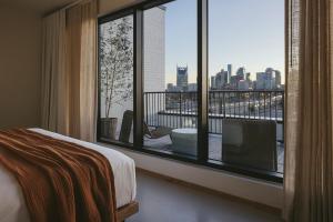 1 dormitorio con ventana grande con vistas a la ciudad en Drift Nashville, a Member of Design Hotels en Nashville