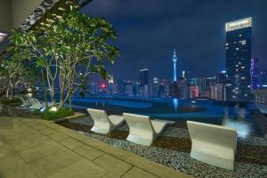 - une vue sur les toits de la ville la nuit depuis un bâtiment dans l'établissement Sleeping Lion Suites, à Kuala Lumpur