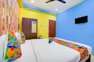 a bedroom with two beds with colorful pillows at FabExpress Nest - Nr Eden Garden Stadium in Kolkata