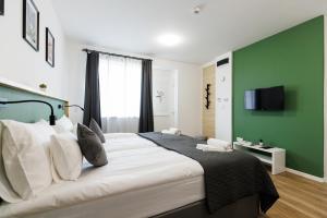 una camera da letto con un grande letto con una parete verde di Safari Hotel a Szeged