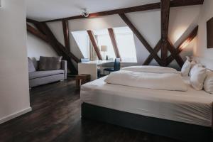 a bedroom with a bed and a table and a couch at Design Hotel & Restaurant Löwen in Ulm