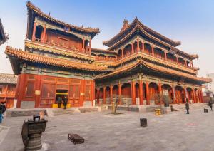 a large orange building with a large building at Lavande Hotel Beijing International Exhibition Heping Xiqiao Metro Station in Beijing