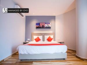 1 dormitorio con 1 cama blanca grande con almohadas rojas en Gs Hotels Near Strand Mall, en Kota Damansara