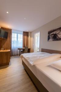 a hotel room with two beds and a desk at Hotel Kronenhof in Schaffhausen