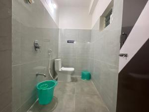 baño con aseo y cubo verde en MGR RESIDENCY, en Srikalahasti