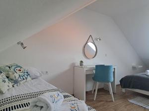 een slaapkamer met een bed en een bureau met een spiegel bij SOLEK Apartamenty i pokoje gościnne in Mielno