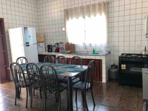 uma cozinha com uma mesa e cadeiras e um frigorífico em Blue Home em Bodoquena